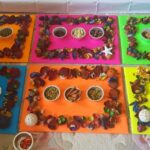 colorful boards adorned with various decorative items and small bowls filled with different types of food.